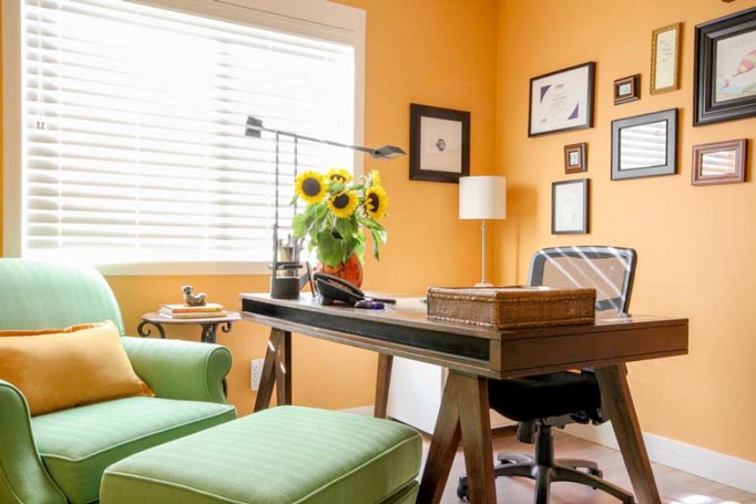 Home office painted orange with green chair