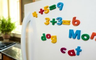 White fridge with Fisher Price refrigerator magnets